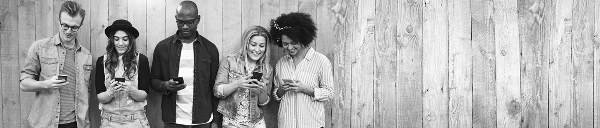 five young adults looking at their cell phones