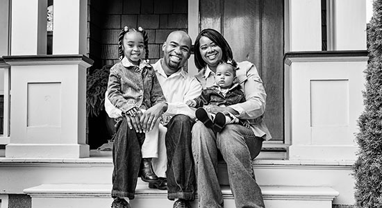 African American family sitting on porch