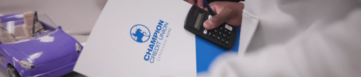 Toy car next to person holding Champion Credit Union folder and calculator.