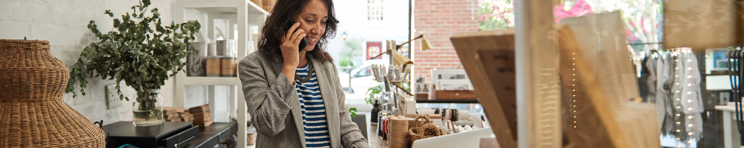 Business woman talking on phone and working on computer.