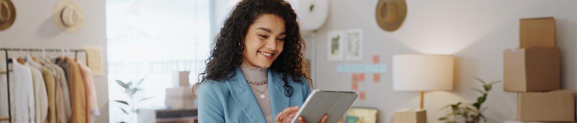 Happy young business woman working on tablet.