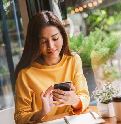 Woman in coffee shop looking at smartphone.