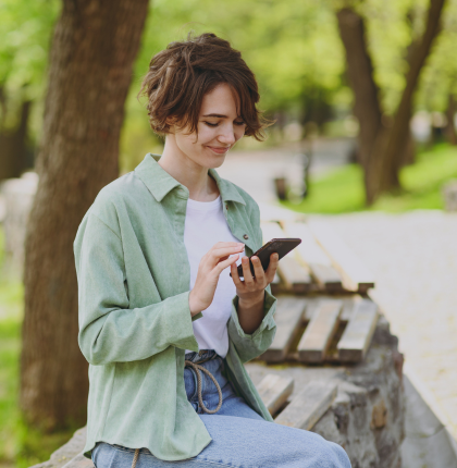Girl using phone on a park bench.