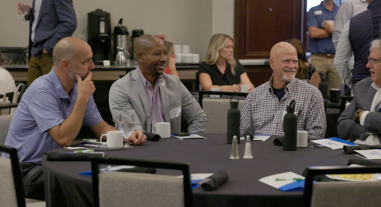 Happy group of people sitting at table talking.