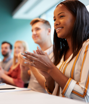 Woman clapping hands in a meeting.