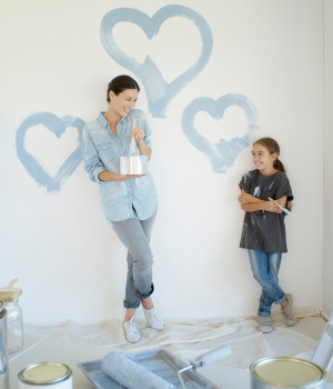 Mother and Daughter painting hearts on wall.