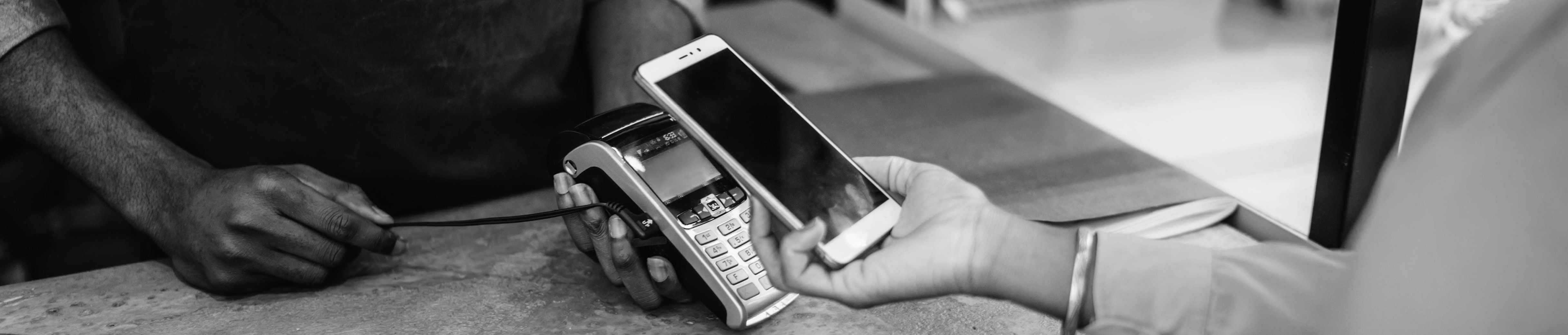 Woman pays cashier with digital wallet on her smartphone.