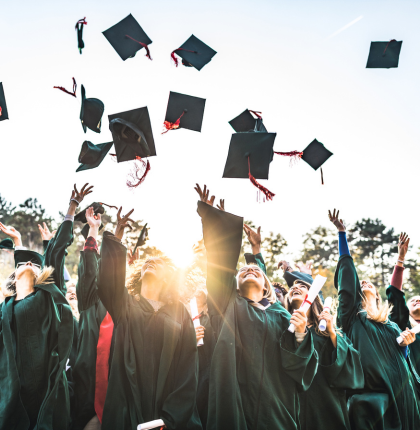 Graduates tossing caps in the air.