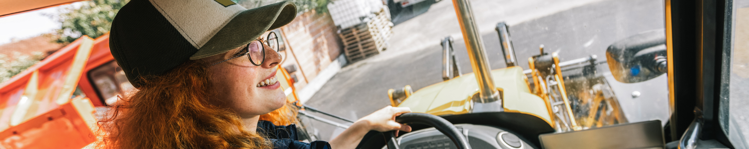 Happy woman driving an excavator.
