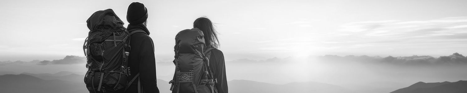 Couple on top of mountains looking at sunset.