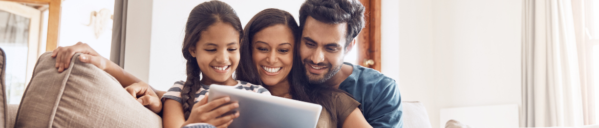 Happy family using tablet on the sofa at home.