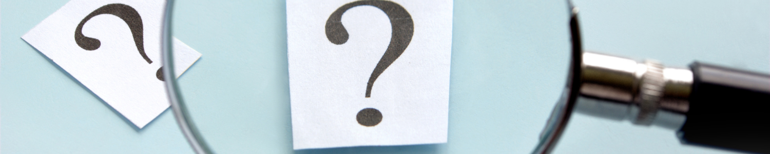 Magnifying glass over question mark.