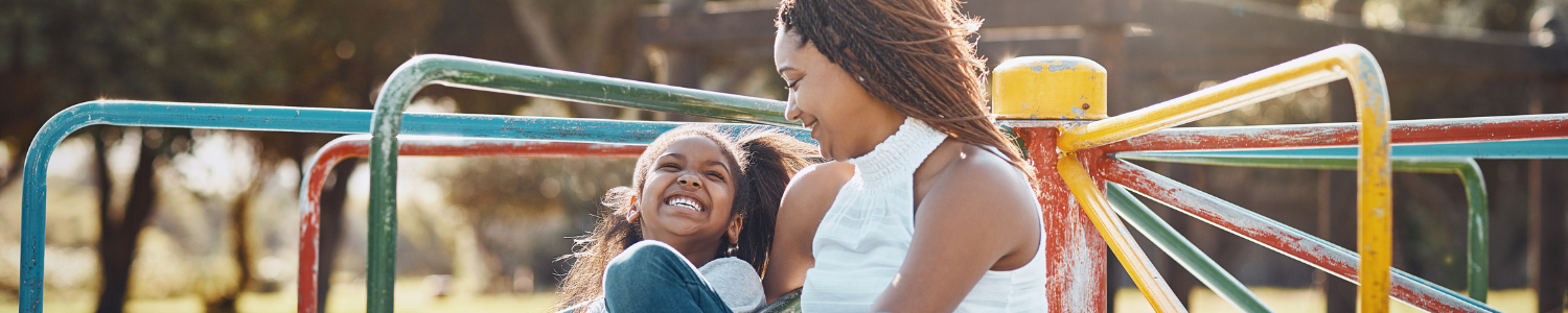 Mother and Daughter happy sitting on playset.