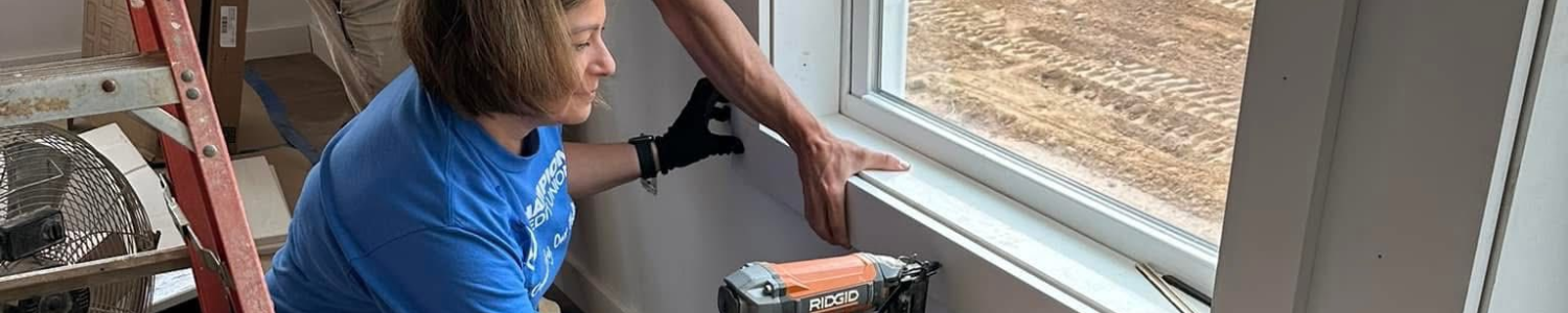 Champion Credit Union Employee Volunteering By Building A Window In A Home.