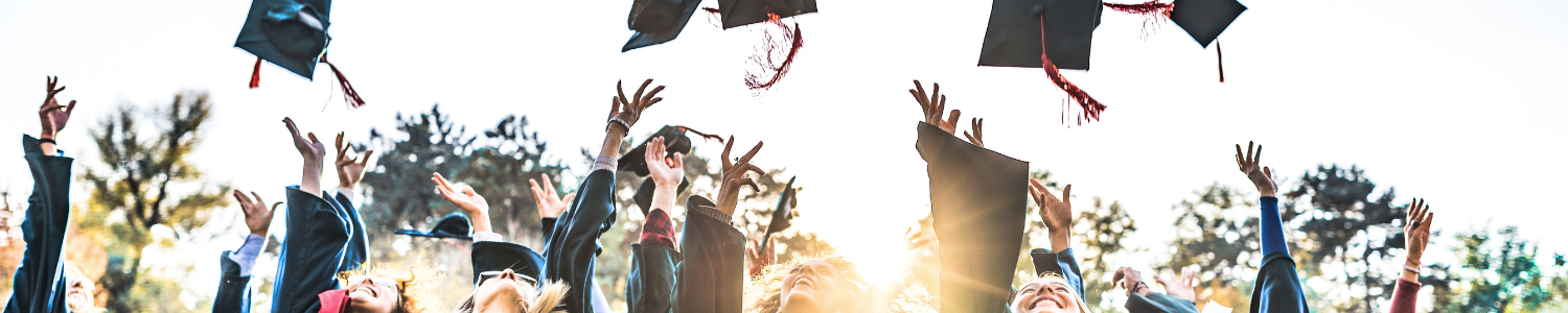 Graduates throwing cap in the air.