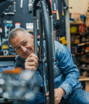 Man in workshop working on bike tire.